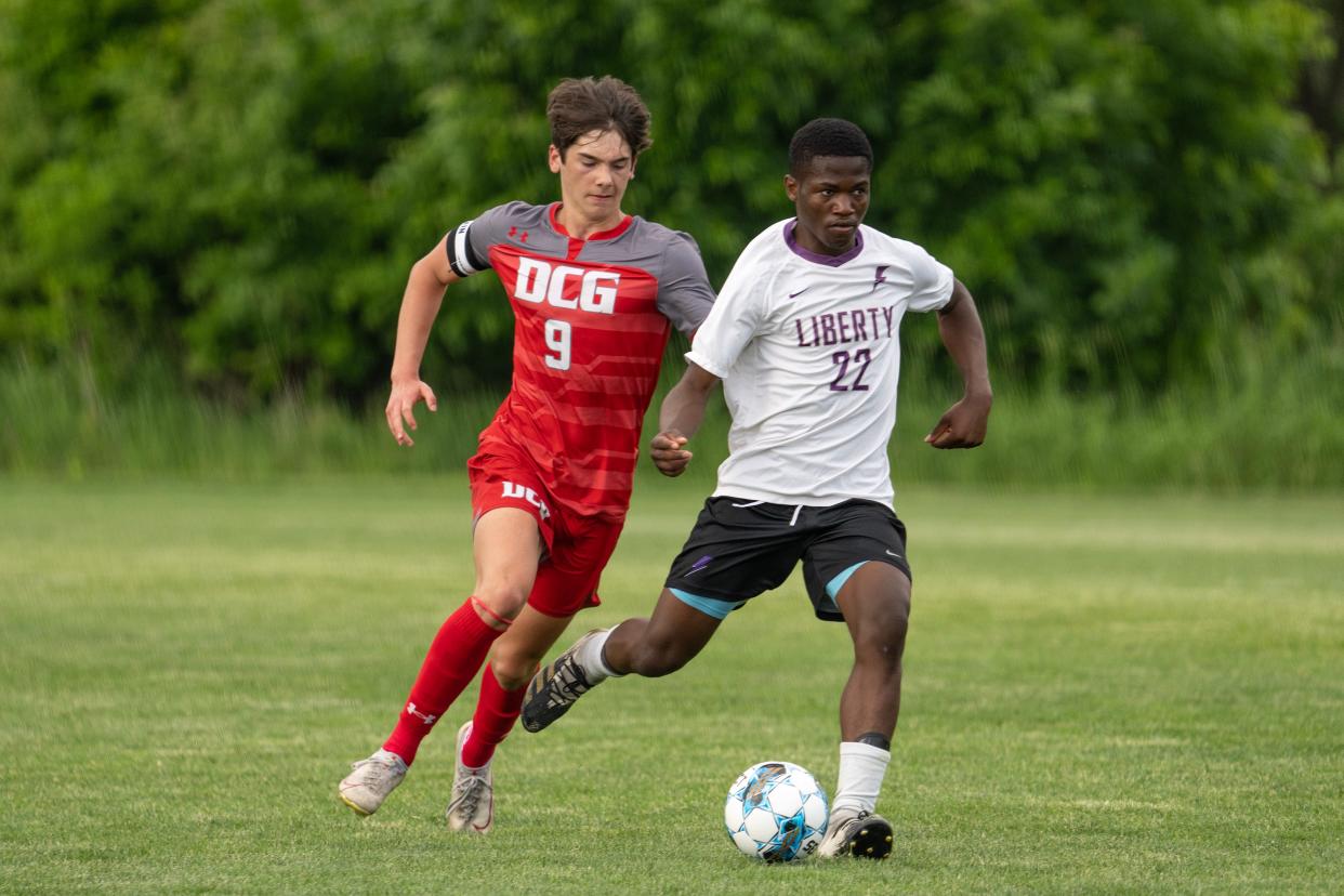 Iowa City Liberty's Wasso Swedi tries to keep the ball away from Dallas Center-Grimes' Ben Jackson during the Class 3A state soccer quarterfinal on Tuesday, May 30, 2023, at the Cownie Soccer Park in Des Moines.