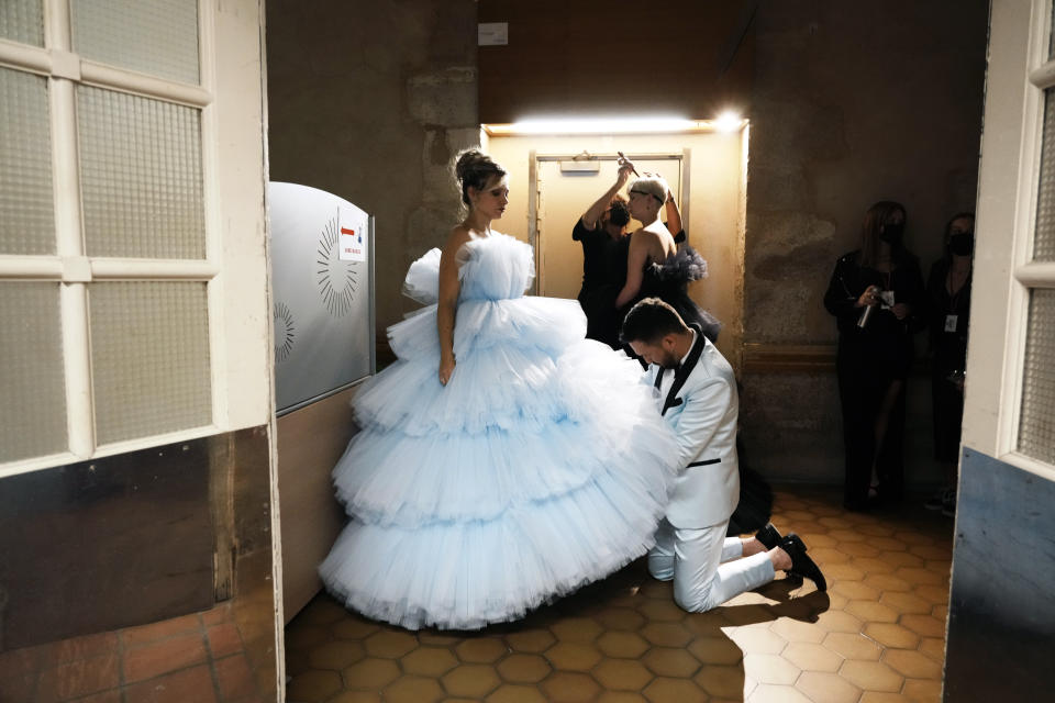 A model, who is an amputee, has her dress adjusted prior to the 'Victoire, on defile!' (Victory, we walk!) fashion show, at the Hotel des Invalides in Paris, Wednesday, Sept. 29 2021. A new collection by Italian designer Fabio Porlod will feature female amputees and women who have been injured. (AP Photo/Thibault Camus)