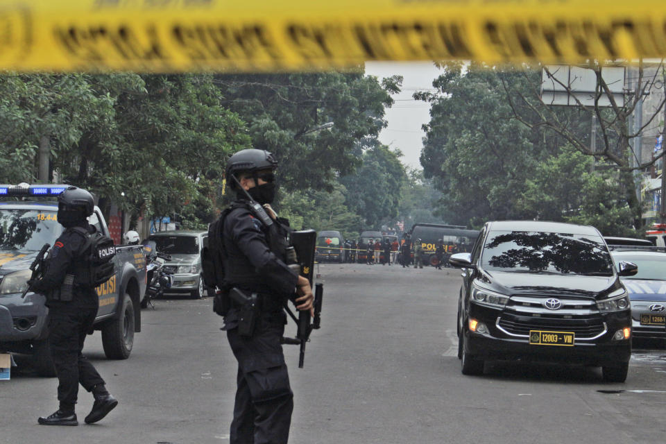 Police officers secure a road leading to a police station where a bomb exploded in Bandung, West Java, Indonesia, Wednesday, Dec. 7, 2022. A man blew himself up Wednesday at a police station on Indonesia's main island of Java in what appeared to be the latest in a string of suicide attacks in the world's most populous Muslim nation. (AP Photo/Kholid Parmawinata)