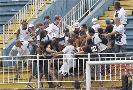 Vasco da Gama soccer fans beat up an Atletico Paranaense fan during their Brazilian championship match in Joinville in Santa Catarina state December 8, 2013. REUTERS/Carlos Moraes