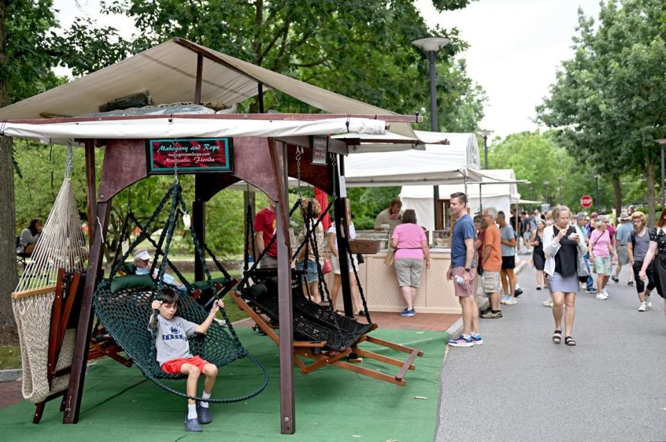 A youngster tries out one of the mahogany and rope swings by Victor Edwards at the Central Pennsylvania Festival of the Arts on Thursday, July 11, 2024.