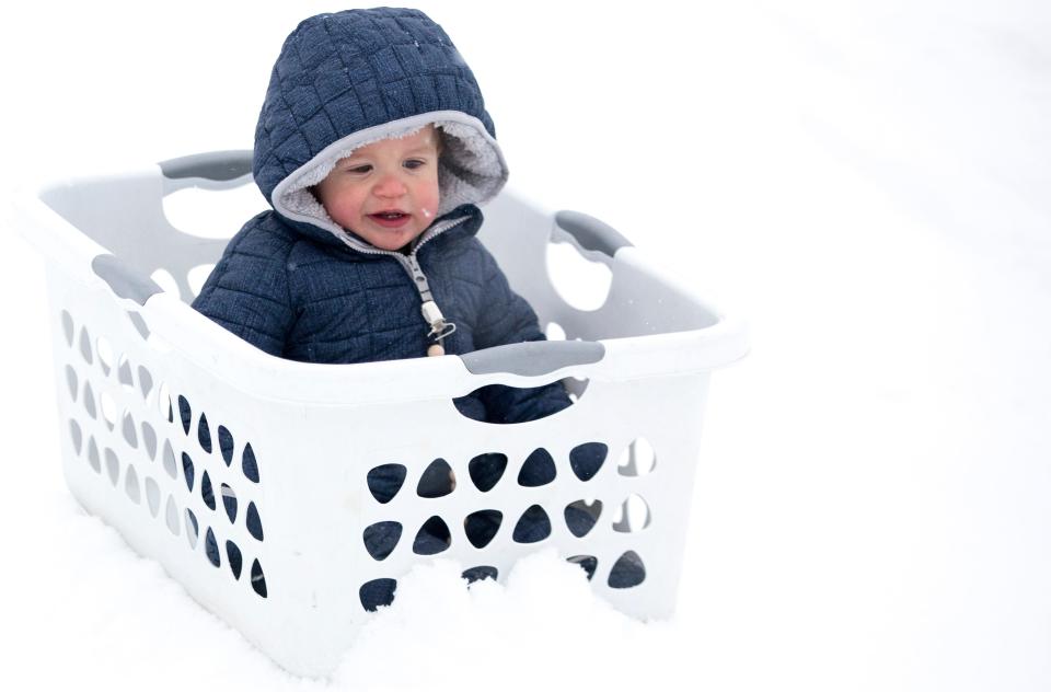 Michael Schneider, 1, goes down a snow covered hill in a laundry basket in Mt. Echo Park in 2021.