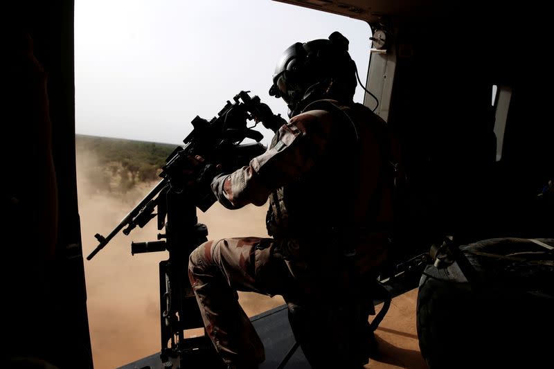 FILE PHOTO: A French soldier mans a machine gun in the door of a NH 90 Caiman military helicopter during Operation Barkhane over Ndaki