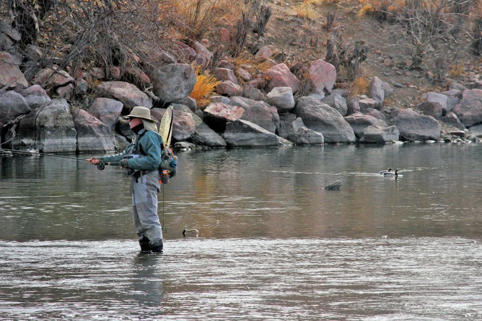 An angler fishes in the Arkansas River below the dam at Lake Pueblo.