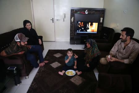 Emad, two, eats food while surrounded by his family at a relative's home in south of Tehran, Iran, June 18, 2017. Nazanin Tabatabaee Yazdi / TIMA via REUTERS.