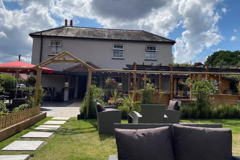 The garden with lawns, grass and a fish pond overlooking the pub