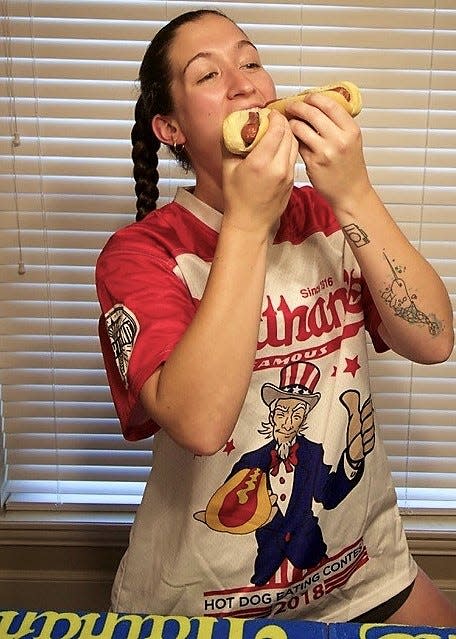 Sophia DeVita poses for her husband, David Gutierrez, before her practice at home in June 2021. She is wearing her official Nathan's Famous jersey from 2018, when she ate 14 to finish sixth in the women's division.