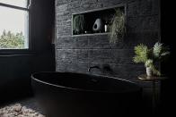 <p>"I wanted to add as much texture as possible to my bathroom, so I clad the wall in faux wooden planks from <a href="https://millboard.co.uk/samples?gclid=Cj0KCQjw9_mDBhCGARIsAN3PaFOn_tXpiKQHHDqLdfDAS2tiQN5Bv65ldpk41_rL88w2_ga5df0UJ0IaAmccEALw_wcB" rel="nofollow noopener" target="_blank" data-ylk="slk:Millboard;elm:context_link;itc:0;sec:content-canvas" class="link ">Millboard</a>. They're intended to be used outside but I love the texture. I then accessorised with plants and rugs. The walls are all plastered with Tadelakt, a Moroccan waterproof plaster. The bath is stone."</p>