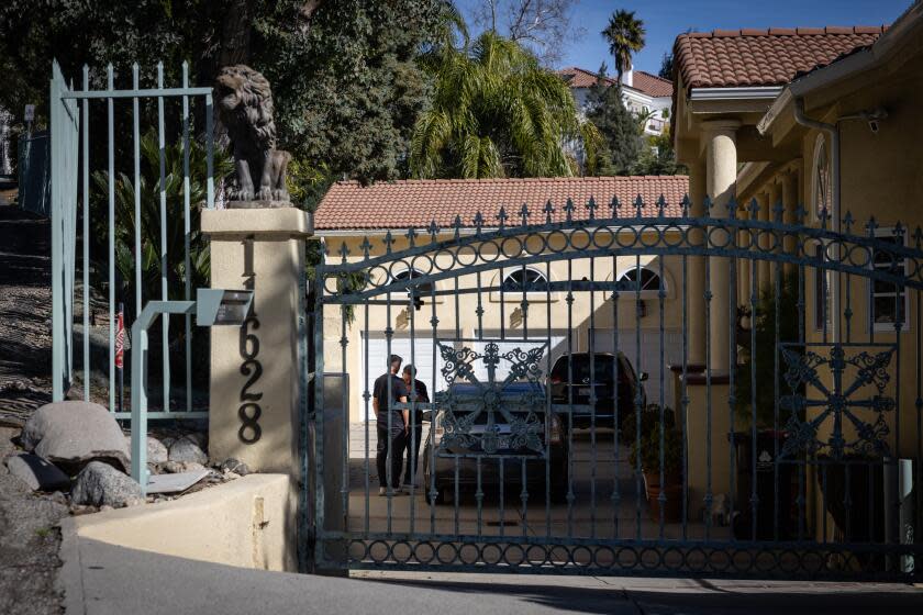 Granada Hills, CA - January 28: People in the driveway of a home where a man in his 80s shot and killed his wife and his two adult children in Granada Hills before turning the gun on himself on Sunday, Jan. 28, 2024 in Granada Hills, CA. (Jason Armond / Los Angeles Times)