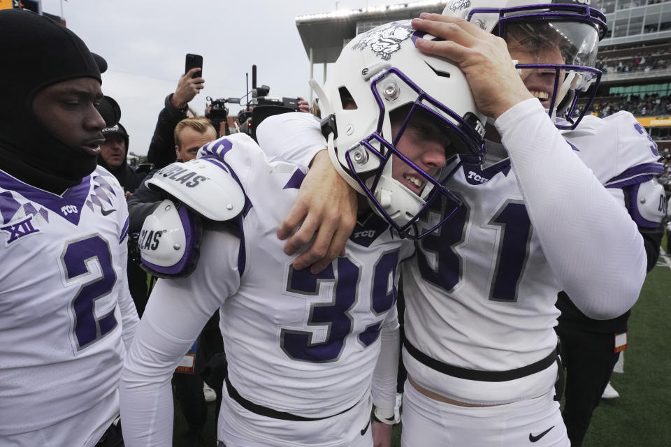 TCU place kicker Griffin Kell (39) celebrates with Jordy Sandy (31) and other teammates after hitting a field goal in the final seconds of an NCAA college football game against Bayor in Waco, Texas, Saturday, Nov. 19, 2022. TCU won 29-28. (AP Photo/LM Otero)