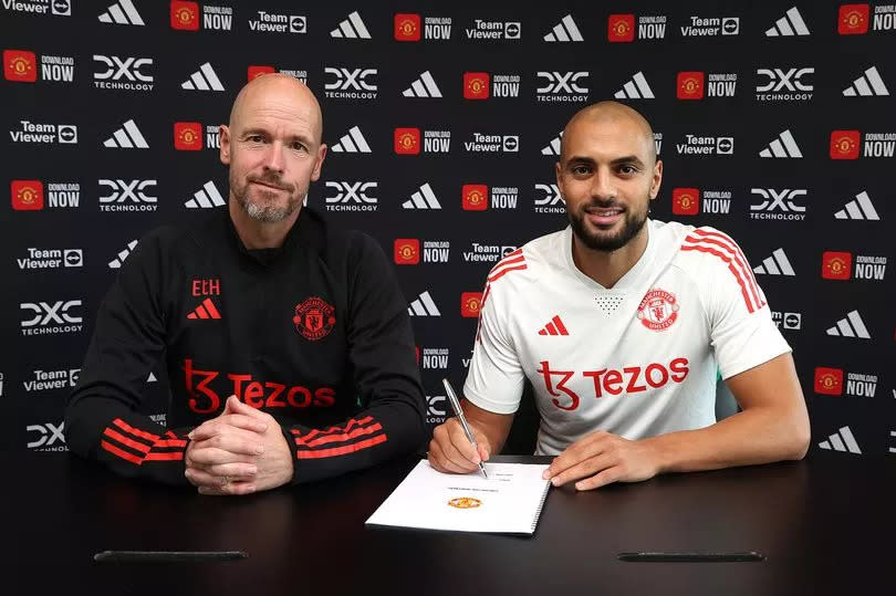 Sofyan Amrabat signs his Manchester United contract sat next to Erik ten Hag.