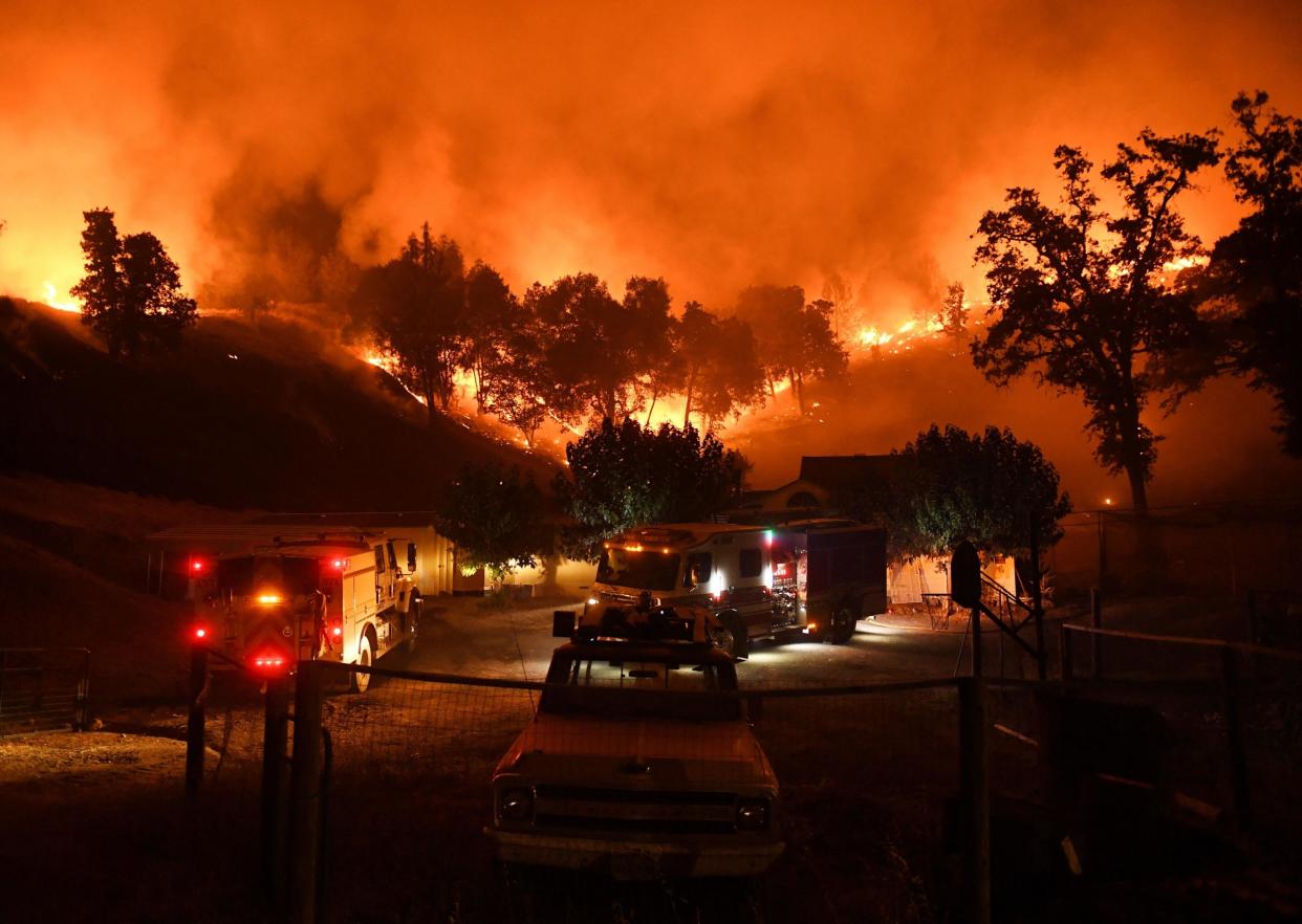 Firefighters conduct a controlled burn to defend houses against flames from the Ranch fire: Getty