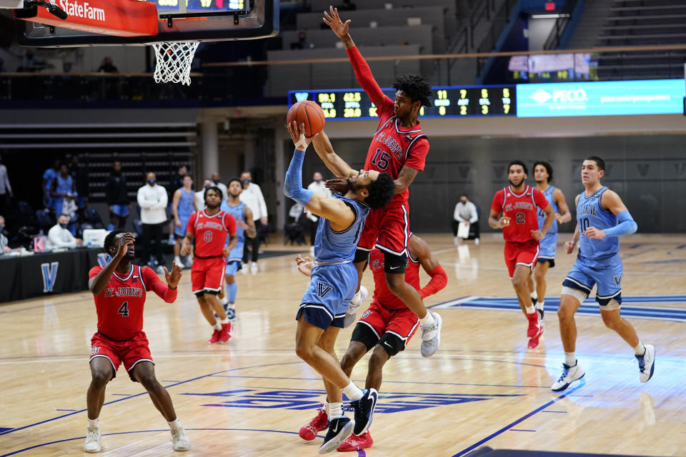 Villanova's Caleb Daniels (14) tries to get a shot past St. John's Vince Cole (15) during the first half of an NCAA college basketball game, Tuesday, Feb. 23, 2021, in Villanova, Pa. (AP Photo/Matt Slocum)