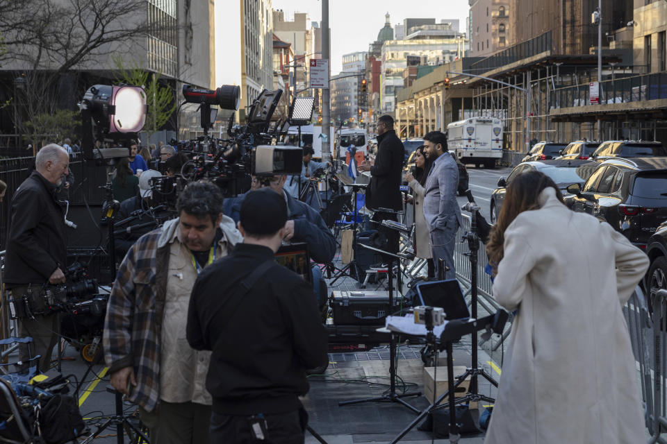 Members of the media gather outside Manhattan Criminal Court, Tuesday, April 16, 2024, in New York. Former President Donald Trump will return to court as a judge works to find a panel of jurors who will decide whether the former president is guilty of criminal charges alleging he falsified business records to cover up a sex scandal during the 2016 campaign. (AP Photo/Yuki Iwamura)