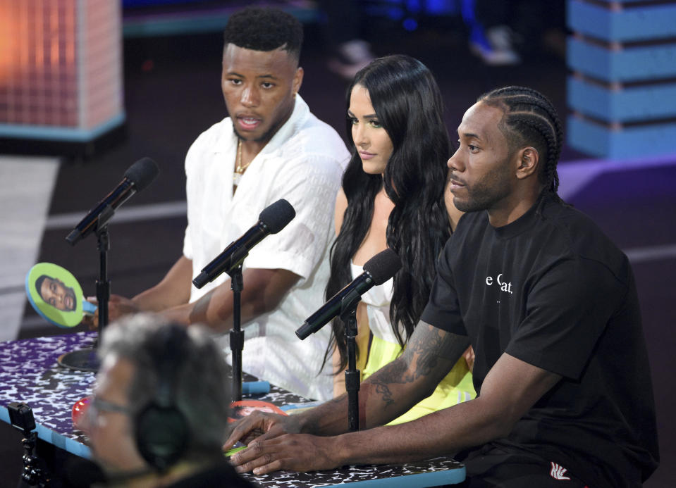 NFL player, Saquon Barkley, of the New York Giants, from left, Nikki Bella, and Kawhi Leonard judge the Pillow Fight Fight Night challenge at the Kids' Choice Sports Awards on Thursday, July 11, 2019, at the Barker Hangar in Santa Monica, Calif. (Photo by Chris Pizzello/Invision/AP)
