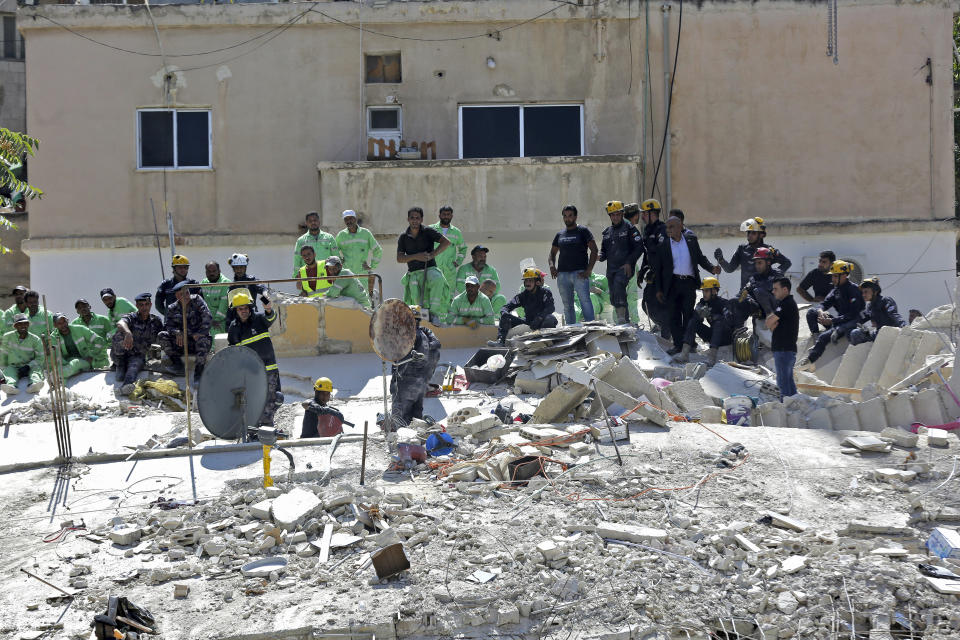 Jordanian Civil Defense rescue teams conduct a search operation for residents of a four-story residential building that collapsed on Tuesday, killing several people and wounding others, in the Jordanian capital of Amman, Wednesday Sept. 14, 2022. Jordanian teams on Wednesday rescued one person alive and worked to save others from the rubble of the collapsed building, officials said. State media said at least five people have been killed and at least 10 others remain missing. (AP Photo/Raad Adayleh)