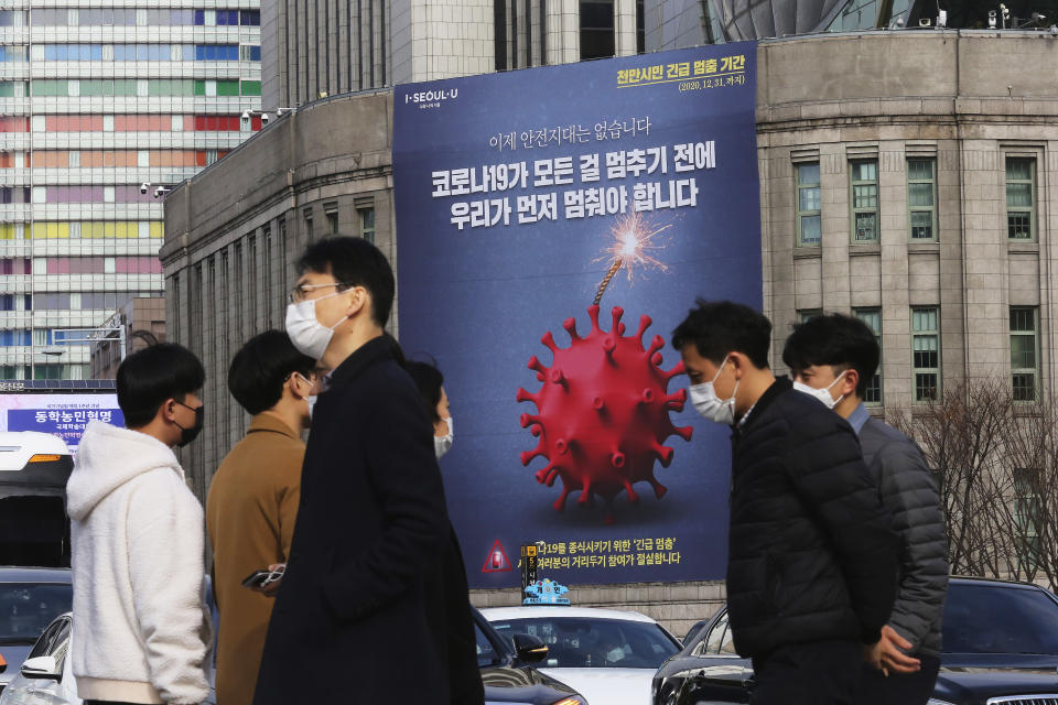 A banner emphasizing an enhanced social distancing campaign is displayed on the wall of Seoul City Hall in Seoul, South Korea, Wednesday, Nov. 25, 2020. The banner reads: "We have to stop before COVID-19 stops everything." (AP Photo/Ahn Young-joon)