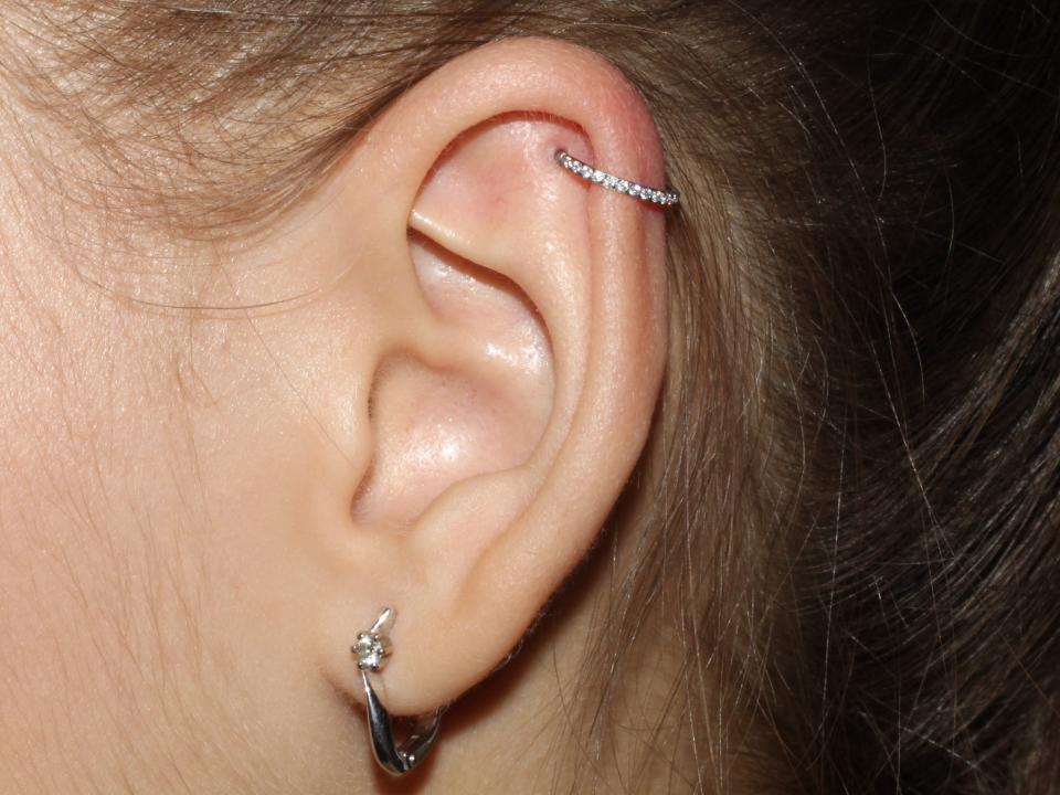 silver hoop in Helix piercing on upper ear