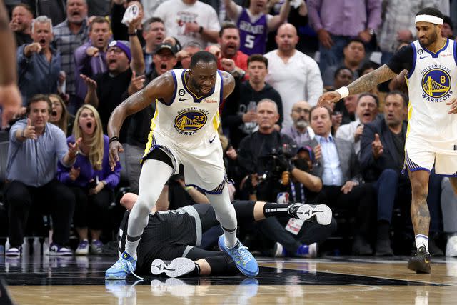 <p>Ezra Shaw/Getty</p> Draymond Green #23 of the Golden State Warriors steps over Domantas Sabonis #10 of the Sacramento Kings in the second half during Game Two of the Western Conference First Round Playoffs on April 17, 2023 in Sacramento, California