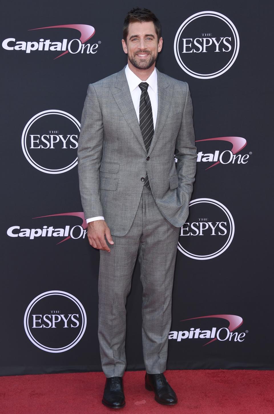 Aaron Rodgers of the Green Bay Packers wearing a gray suit