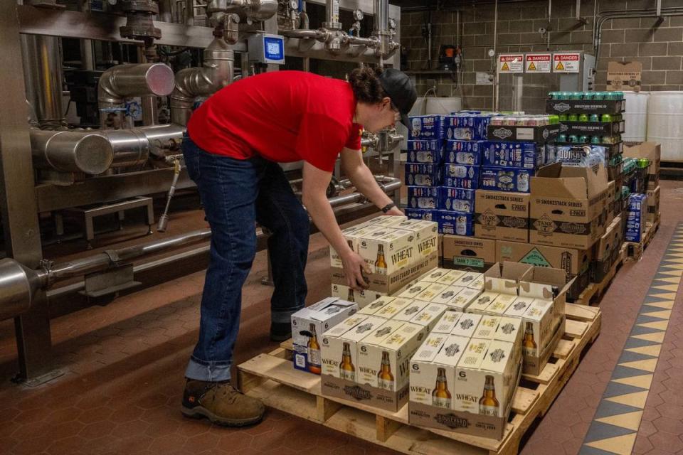 A Boulevard associate places a case of Unfiltered Wheat on a pallet for employees to take home.