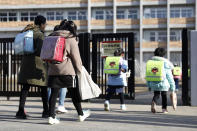 Students arrives at their elementary school in Sendai, northern Japan, Friday morning, Feb. 28, 2020, a day after Japanese Prime Minister Shinzo Abe's announcement. Abe asked all elementary, middle and high schools nationwide on Thursday to close until late March from March 2 to help control the spread of the new virus in the country. (Hironori Asakawa/Kyodo News via AP)