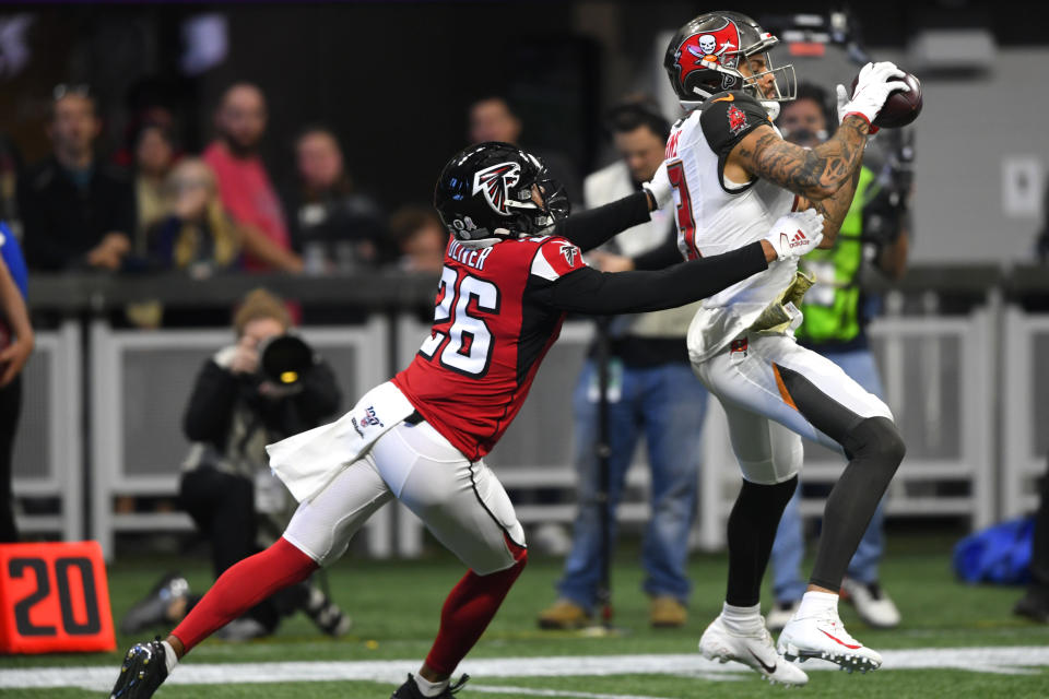 Tampa Bay Buccaneers wide receiver Mike Evans (13) makes the catch against Atlanta Falcons cornerback Isaiah Oliver (26) during the first half of an NFL football game, Sunday, Nov. 24, 2019, in Atlanta. (AP Photo/John Amis)