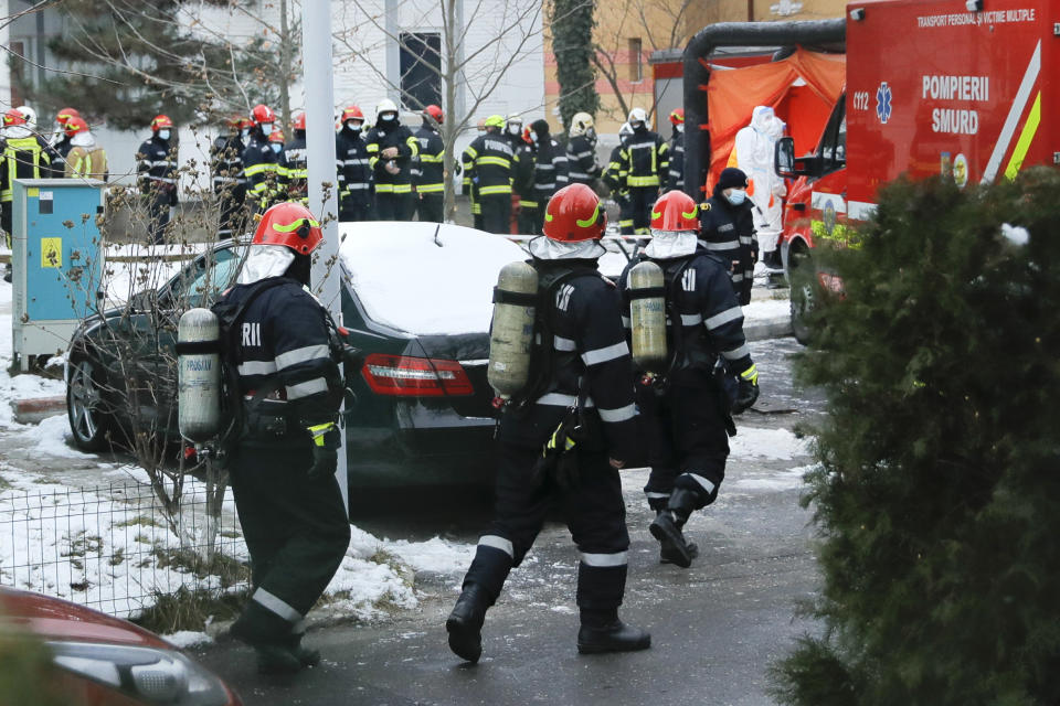 Firefighters walk at the the Matei Bals hospital compound after a fire broke out in one of its buildings in Bucharest, Romania, Friday, Jan. 29, 2021. A fire early Friday at a key hospital in Bucharest that also treats COVID-19 patients killed four people, authorities said. (AP Photo/Vadim Ghirda)