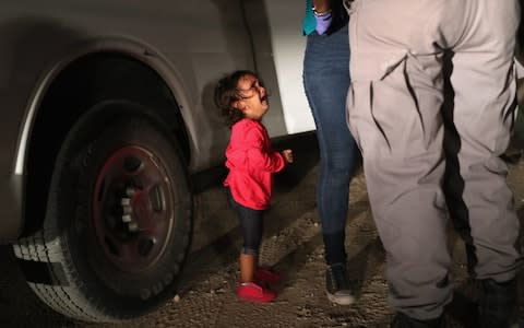 A two-year-old Honduran asylum seeker cries as her mother is searched and detained near the U.S.-Mexico border on June 12, 2018 in McAllen, Texas - Credit: Getty
