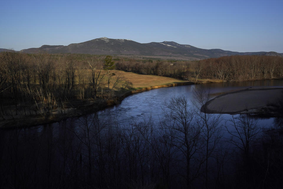 Moat Mountain towers over farmland beyond the Saco River in Conway, N.H., Thursday, April 13, 2023. A mural depicting pastries meant to evoke a mountain range is at the center of a zoning dispute between a local bakery and the town. (AP Photo/Robert F. Bukaty)