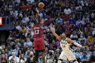 Miami Heat center Bam Adebayo (13) shoots over Milwaukee Bucks forward Giannis Antetokounmpo (34) during the first half of an NBA basketball game Thursday, Oct. 21, 2021, in Miami. (AP Photo/Lynne Sladky)