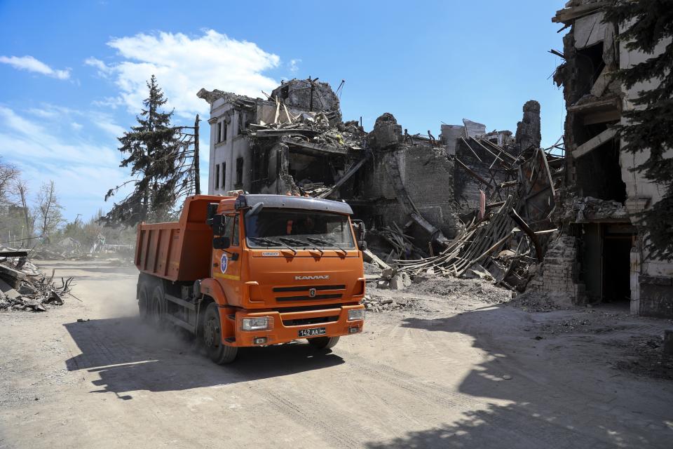 A truck drives past the Mariupol theater damaged during fighting in Mariupol, in territory under the government of the Donetsk People's Republic, eastern Ukraine, Wednesday, April 27, 2022. Municipal services began clearing rubble and cleaning the city. (AP Photo/Alexei Alexandrov)