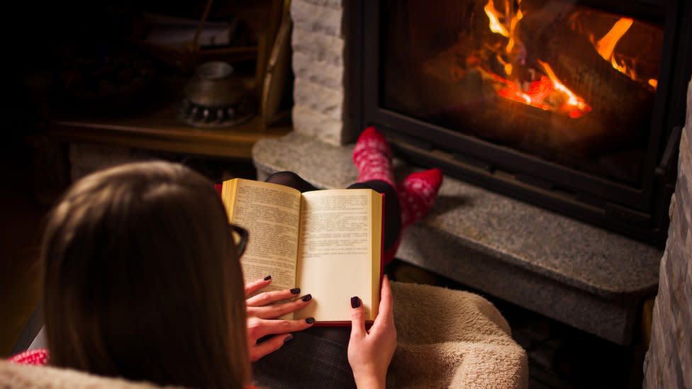 Woman reading in front of stove