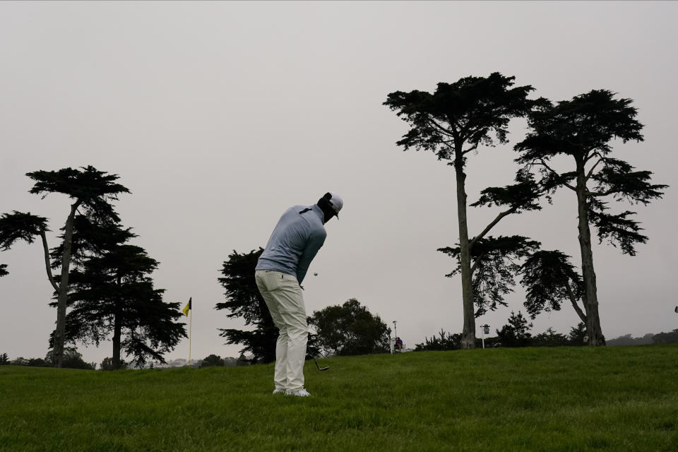 Tony Finau chips to the green on the 10th hole during the first round of the PGA Championship golf tournament at TPC Harding Park Thursday, Aug. 6, 2020, in San Francisco. (AP Photo/Jeff Chiu)