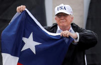 <p>President Donald Trump holds a flag of the state of Texas after receiving a briefing on Tropical Storm Harvey relief efforts at a local fire station where residents gathered to welcome the president in Corpus Christi, Texas, Aug. 29, 2017. (Photo: Carlos Barria/Reuters) </p>