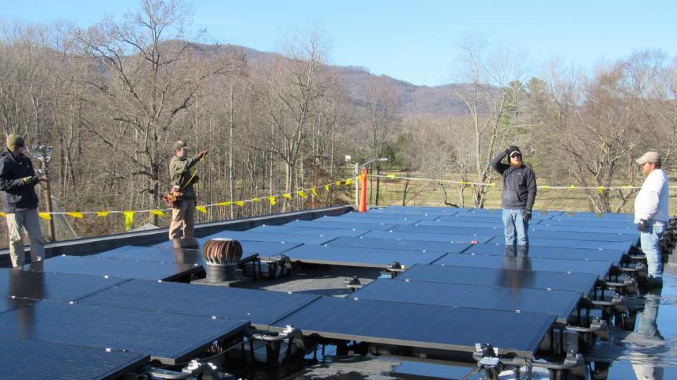 Employees of HOMES Inc. discuss installion of solar panels on the Middlesboro Community Center on Dec. 7, 2023. From left, they are Kelly Sexton, Reuben Long, Keylan Vanover and Derrick Potter .