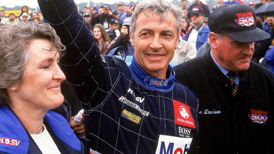 Peter Brock is pictured waving to fans in 1997, alongside then wife Bev.