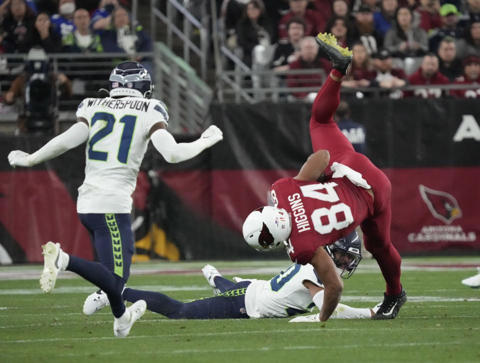 Arizona Cardinals tight end Elijah Higgins (84) is tackled by Seattle Seahawks safety Julian Love (20) after a catch during the fourth quarter at State Farm Stadium in Glendale on Jan. 7, 2024.