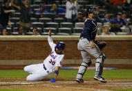 New York Mets Michael Conforto, left, scores against the Atlanta Braves during the seventh inning of a baseball game Wednesday, June 23, 2021, in New York. (AP Photo/Noah K. Murray)