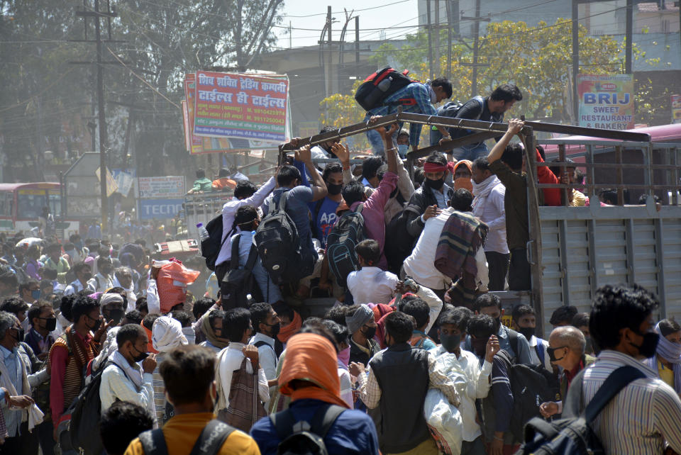 GHAZIABAD, INDIA - MARCH 28: Migrant workers try to board a goods truck bound to their native state during Day 4 of the 21 day nationwide lockdown -- to check the spread of coronavirus, at Lal Kuan bus stand, on March 28, 2020 in Ghaziabad, India. (Photo by Sakib Ali/Hindustan Times via Getty Images)