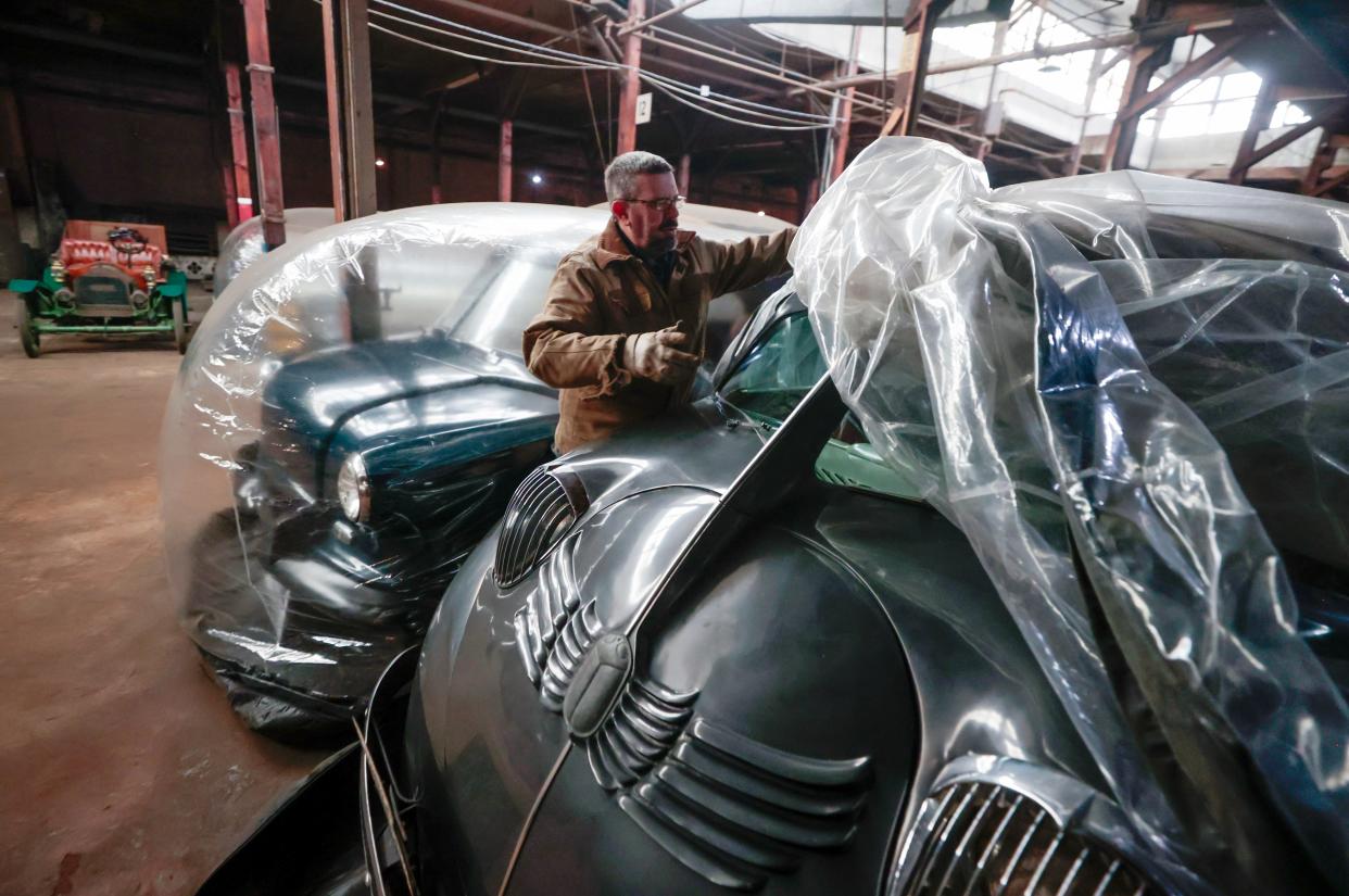 Dave Marchioni, 55, of St. Clair Shores and the industrial and automotive curator for the Detroit Historical Society, pulls back the protective cover on a 1934 Stout Scarab on Nov. 9, 2023, at the Collections Resource Center in Detroit. The Scarab is one of 60 vehicles that is kept in storage. The vehicles are occasionally rotated into exhibition at the Detroit Historical Museum on Woodward in Detroit. The Scarab was a car made in the Detroit area, at Scott Street and Telegraph in Dearborn. This one is one of six remaining with three of them in the state of Michigan. Two of those Scarabs are missing and there is an urban legend that one of them was used as a ice shanty and sank when the ice thawed.