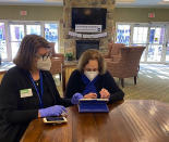 This photo provided by Atria on Feb. 11, 2021 shows Barbara Moran, Engage Life Director at Atria Cranford helps resident Paula Mont shop on Amazon in Cranford, N.J. The pandemic has sparked a surge of online shopping across all age groups as people stay away from physical stores. But the biggest growth has come from consumers 65 and older. They range from beginners like Mont who struggle with the basics to those who are breezily shifting more of their buying to the web. (Atria via AP)