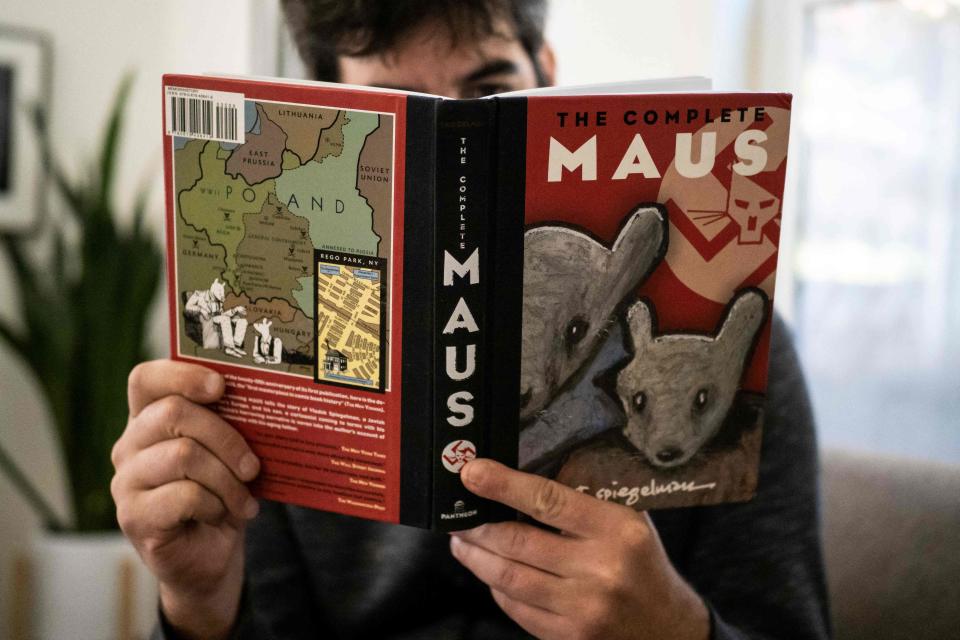 This illustration photo taken in Los Angeles on Jan. 27, 2022, shows a person holding the graphic novel "Maus" by Art Spiegelman.