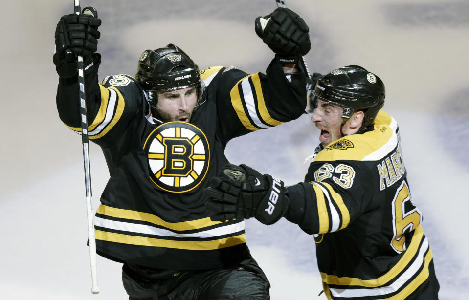 Boston Bruins defenseman Johnny Boychuk, left, raises his arms as he celebrates his tying goal, which forced the game into overtime, against the Montreal Canadiens during the third period of Game 1 in the second-round of the Stanley Cup playoff series in Boston, Thursday, May 1, 2014. At right is center Brad Marchand. (AP Photo/Charles Krupa)