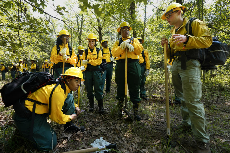 Students listen to instruction from instructor Ben McLane, right, during a wildland firefighter training Friday, June 9, 2023, in Hazel Green, Ala. A partnership between the U.S. Forest Service and four historically Black colleges and universities is opening the eyes of students of color who had never pictured themselves as fighting forest fires. (AP Photo/George Walker IV)