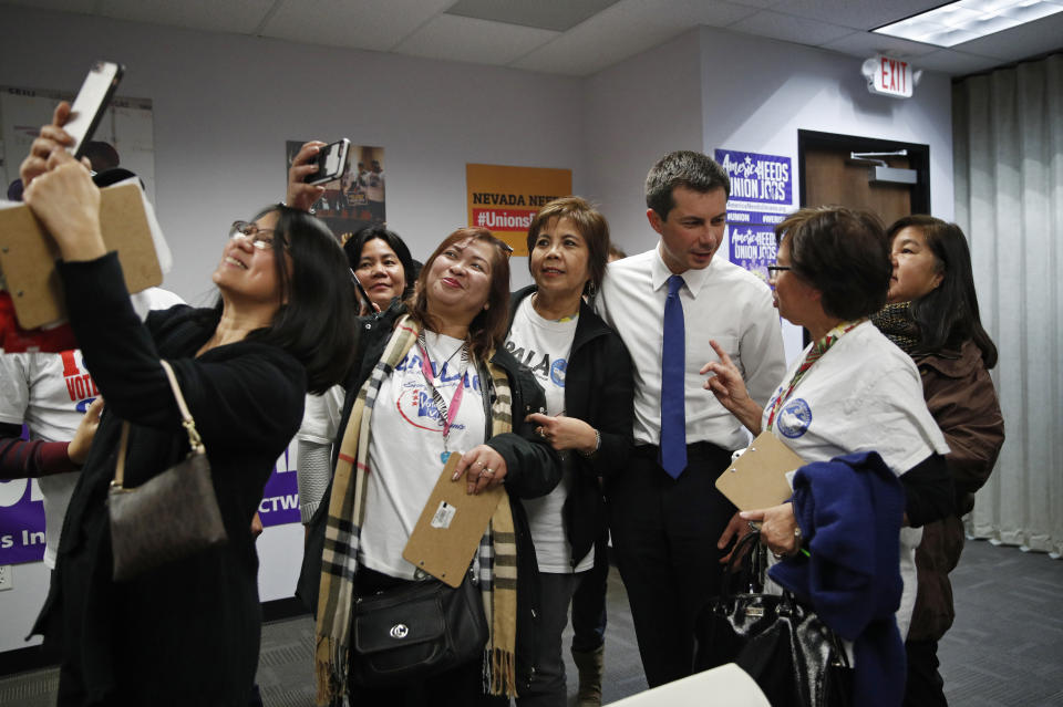 Democratic presidential candidate South Bend, Ind., Mayor Pete Buttigieg, third from right, meets with people as others take selfies at a town hall event with Asian American and Pacific Islander voters Friday, Dec. 20, 2019, in Las Vegas. (AP Photo/John Locher)