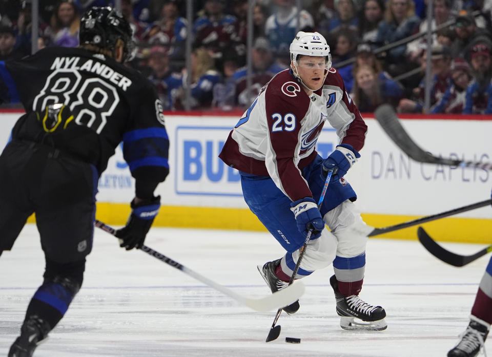 Colorado Avalanche center Nathan MacKinnon, right, drives with the puck as Toronto Maple Leafs right wing William Nylander drops back to defend in the first period of an NHL hockey game Saturday, Feb. 24, 2024, in Denver. (AP Photo/David Zalubowski)