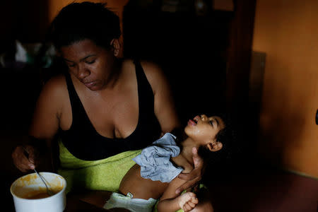 Tatiana Rocha feeds her son Kaleth Heredia, 2, neurological patient being treated with anticonvulsants, at their house in Caracas, Venezuela February 3, 2017. REUTERS/Carlos Garcia Rawlins