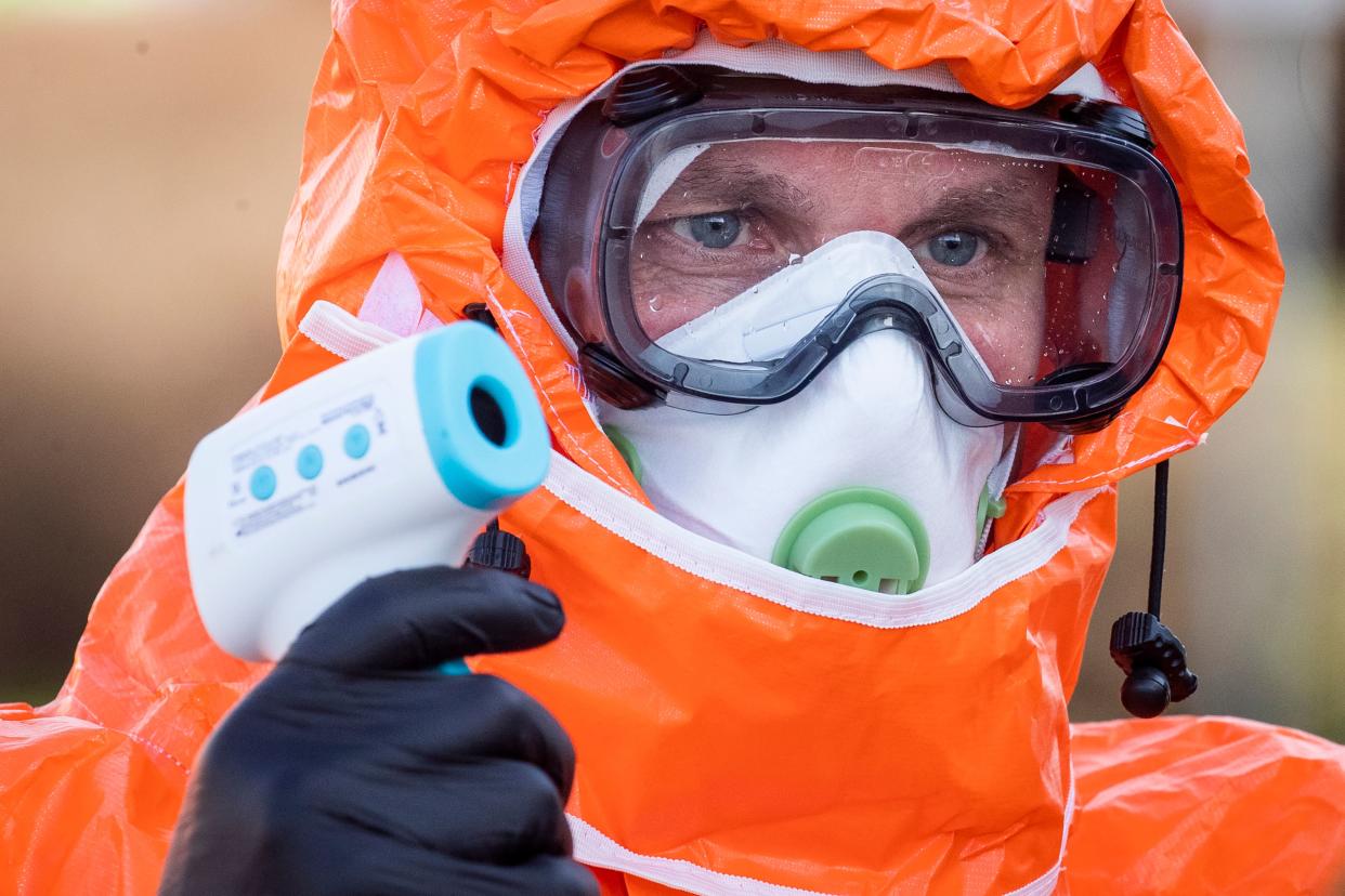 A Polish health official checks the temperature of returning Poles  crossing the Polish-German border from the eastern German town of Frankfurt (Oder) to Slubice on March 16, 2020, in a measure to slow down the spread of the novel coronavirus. - Polish Prime Minister Mateusz Morawiecki said Poland's borders would be closed to foreigners for 10 days, but that the government might prolong the shutdown. Two weeks of quarantine will also be imposed on people returning from abroad. (Photo by Odd ANDERSEN / AFP) (Photo by ODD ANDERSEN/AFP via Getty Images)