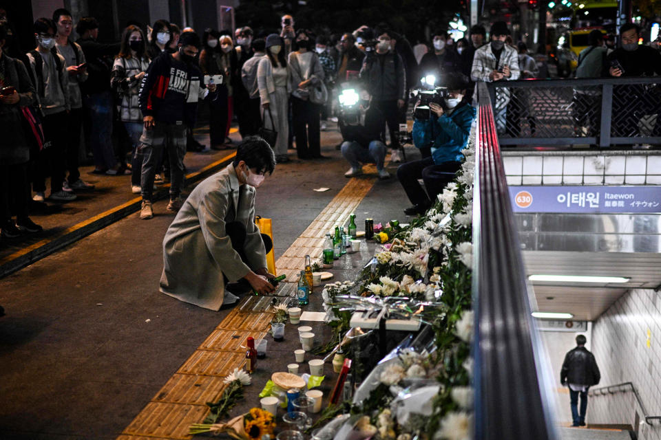 A man pours a glass of an alcoholic beverage, in tribute to those who were killed in a Halloween stampede late on Saturday in Seoul's Itaewon district, on Oct. 30, 2022. (Anthony Wallace / AFP - Getty Images)